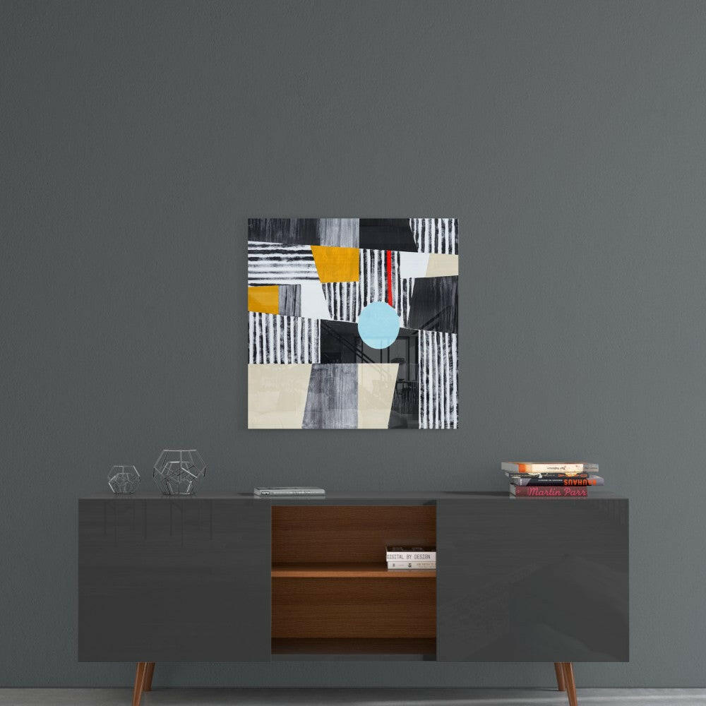 Abstract glass wall art with striped patterns, geometric shapes in black, white, cream, yellow, and light blue circle, displayed above mid-century modern credenza.
