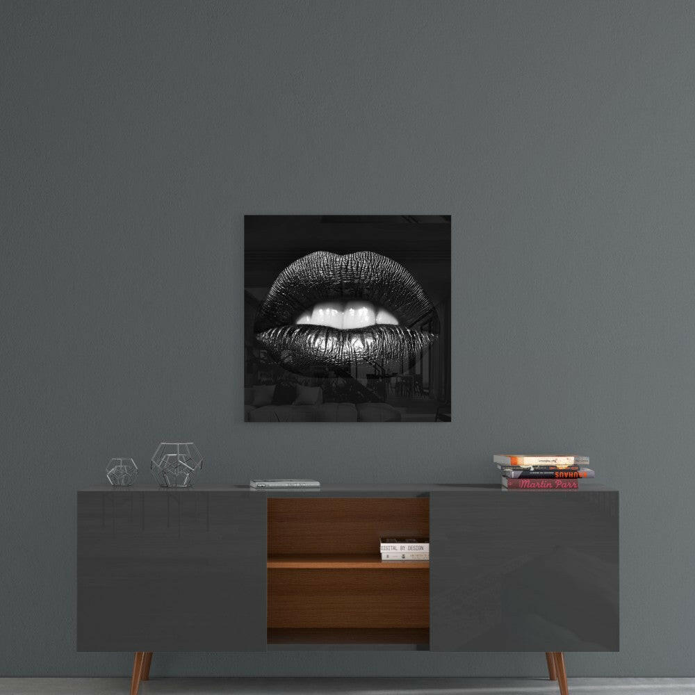 Black and white glass wall art featuring glossy lips displayed above a mid-century modern credenza in a styled interior setting.