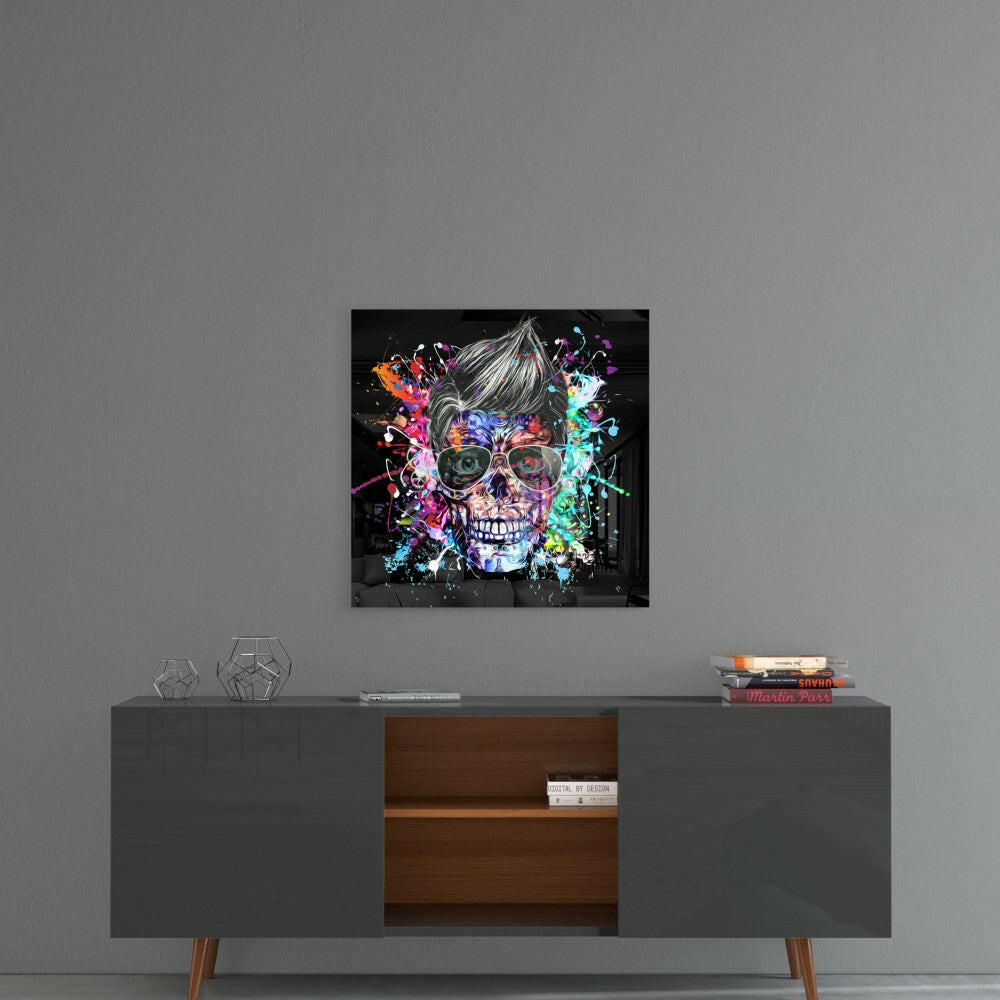 Colorful neon skull with glasses and paint splatter design mounted on gray wall above mid-century modern console table.