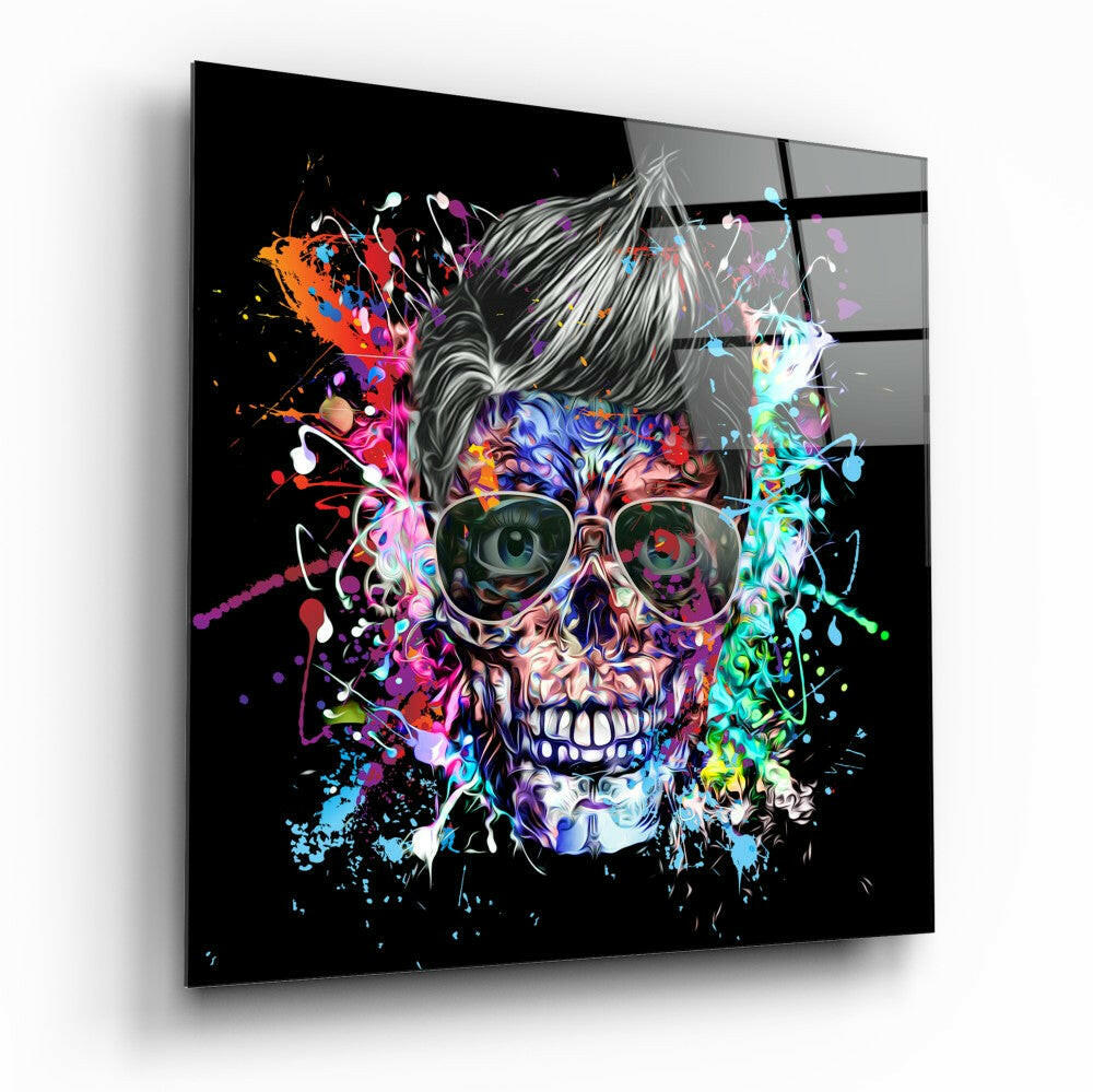 Angled view of a square glass wall panel featuring a colorful skull with sunglasses and vibrant paint splatters on black background.