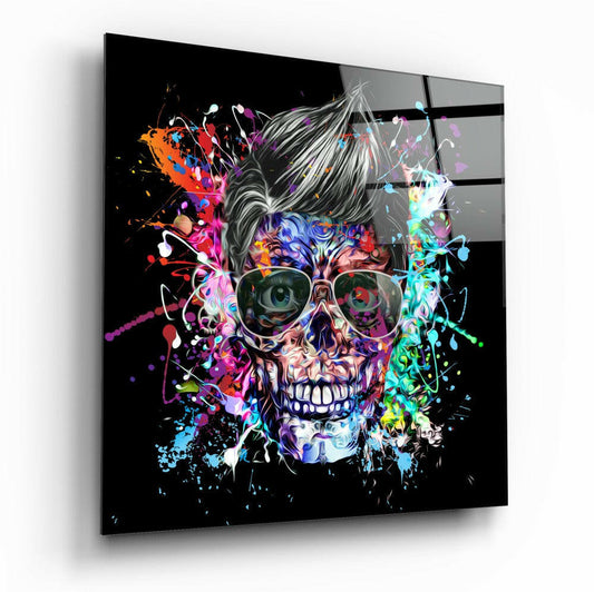 Angled view of a square glass wall panel featuring a colorful skull with sunglasses and vibrant paint splatters on black background.