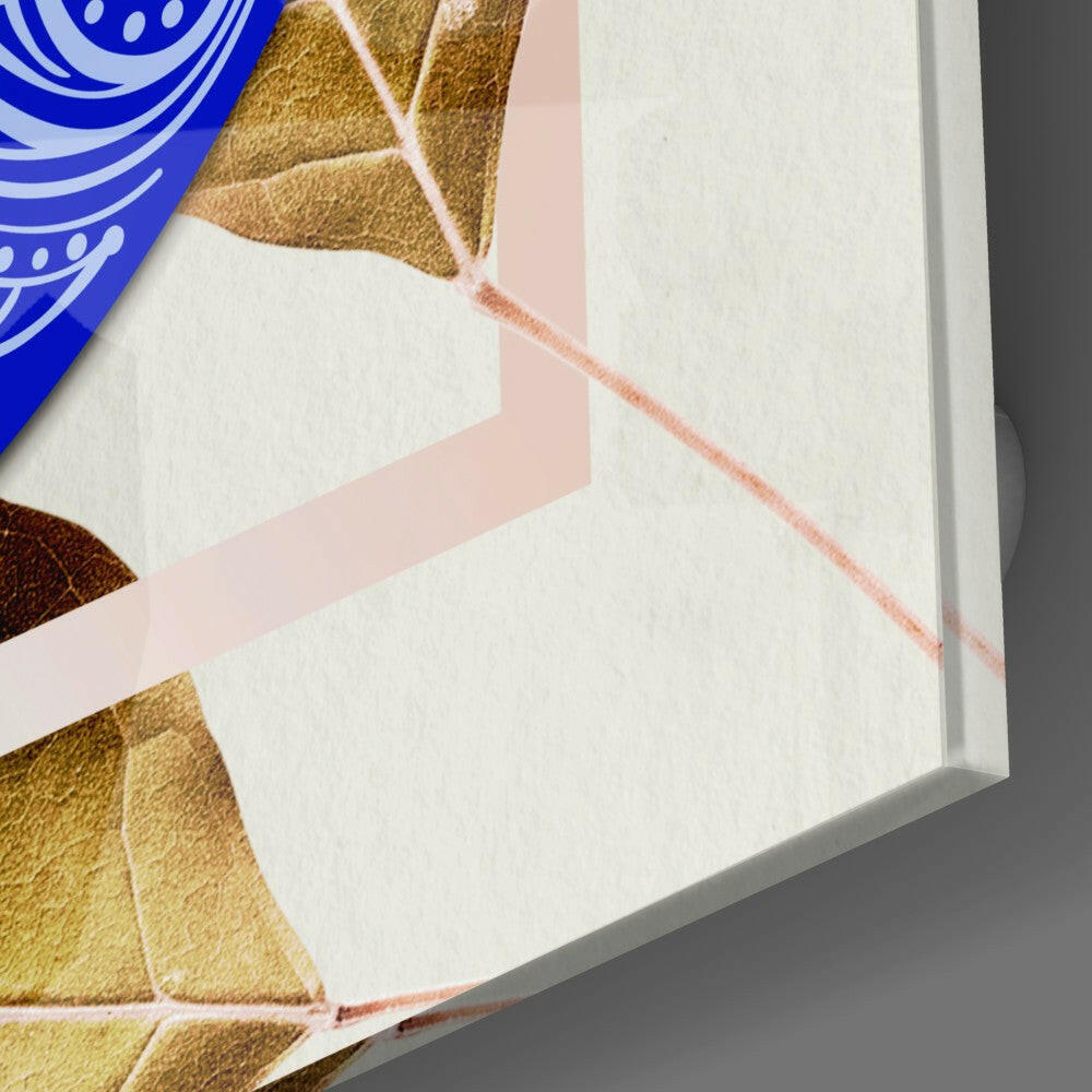 Close-up of packaged blue evil eye wall art showing gold leaf design and pink ribbon detail on white box edge.
