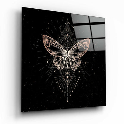 Square glass panel displaying a gold geometric butterfly design with sacred symbols on black background, angled perspective view.