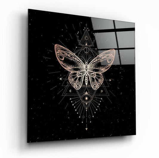 Square glass panel displaying a gold geometric butterfly design with sacred symbols on black background, angled perspective view.