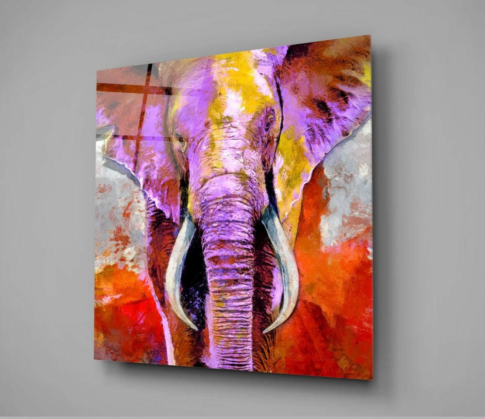 Colorful glass wall art featuring a vibrant purple, yellow, and red elephant head with white tusks, displayed at an angle against a gray background.