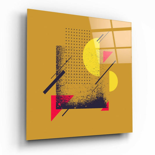 Angled view of gold glass wall art featuring geometric shapes in yellow, pink, and navy with dotted and textured patterns.