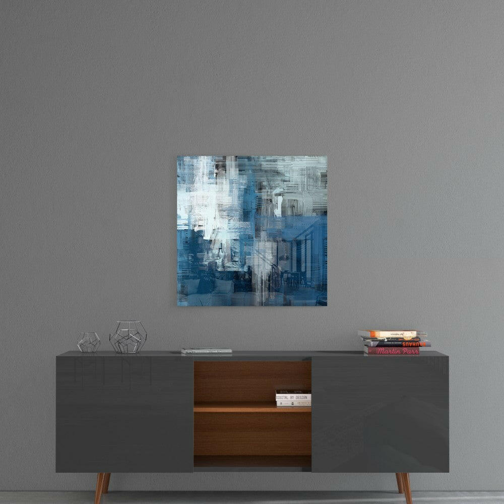 Blue and white abstract glass wall art hanging above a mid-century modern console table with geometric decorative objects.