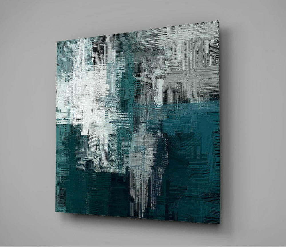 Abstract glass wall art with teal, white, and dark gray brushstroke patterns mounted on light gray wall.