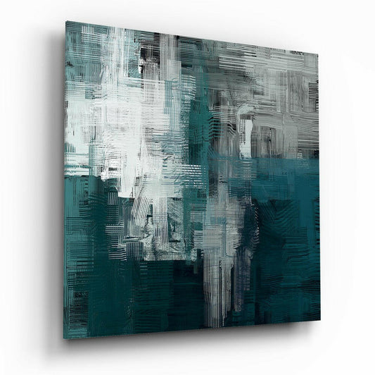 Abstract glass wall art panel with layered teal, white, and gray brushstroke patterns, photographed at an angle showing dimensional depth and shadow.