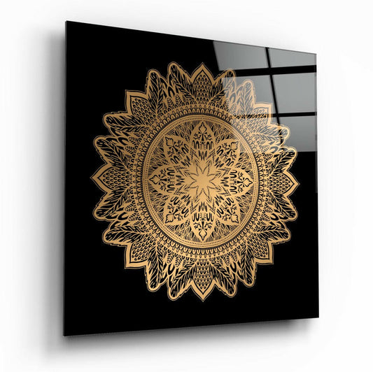 Gold ornate mandala design on black glass panel displayed at an angle, showing reflections on the surface.