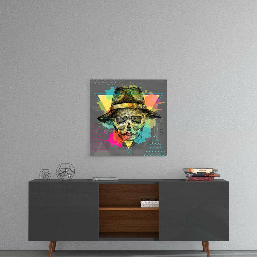 Colorful pop art skull wearing a fedora hat displayed on gray wall above mid-century modern console table.