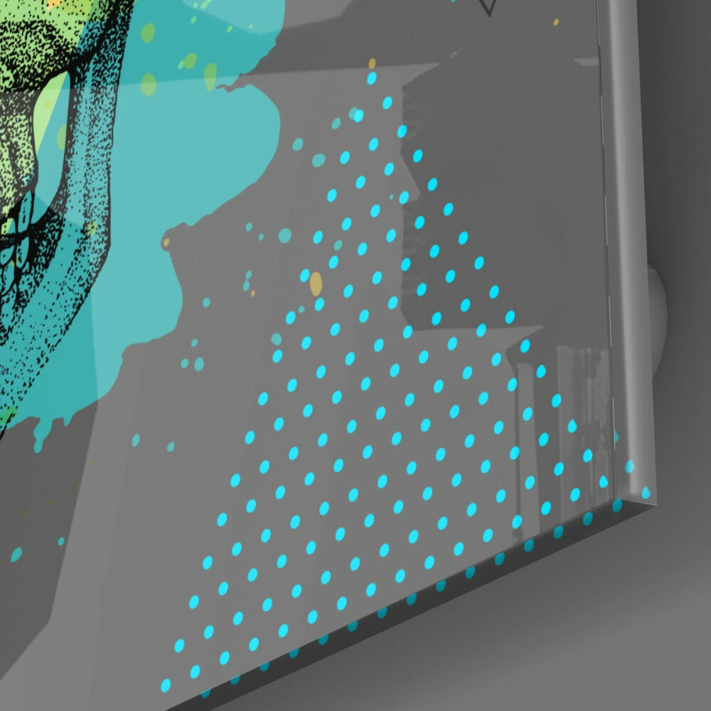 Close-up angled view of glass wall art showing cyan dotted pattern on gray surface with turquoise organic shapes and black textured elements in upper left corner.