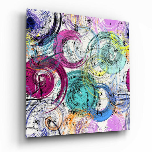 Angled view of colorful glass wall art displaying overlapping spiral circles in magenta, cyan, yellow, and blue with black linear accents on white background.