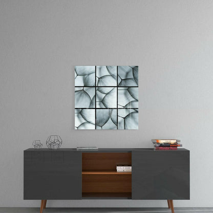 Nine-panel glass wall art with monochromatic dandelion seed heads displayed above a mid-century modern console table.