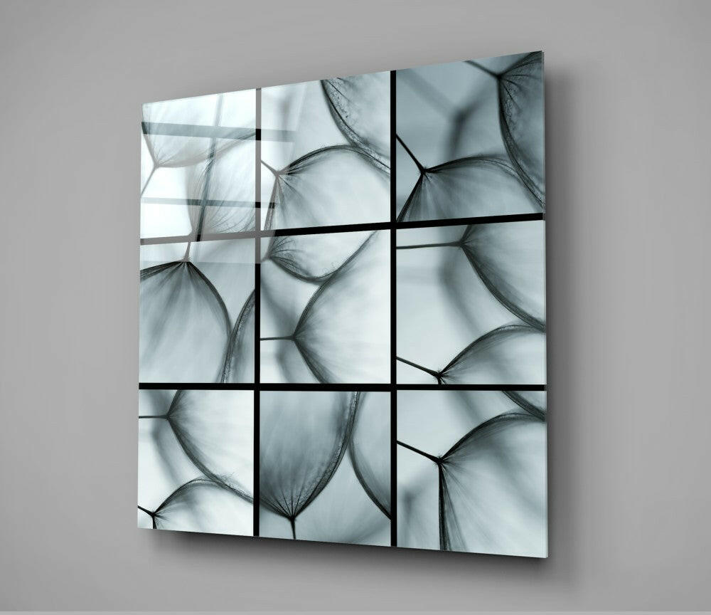Nine-panel glass wall art featuring translucent dandelion seed heads in grayscale, mounted at an angle against a neutral background.