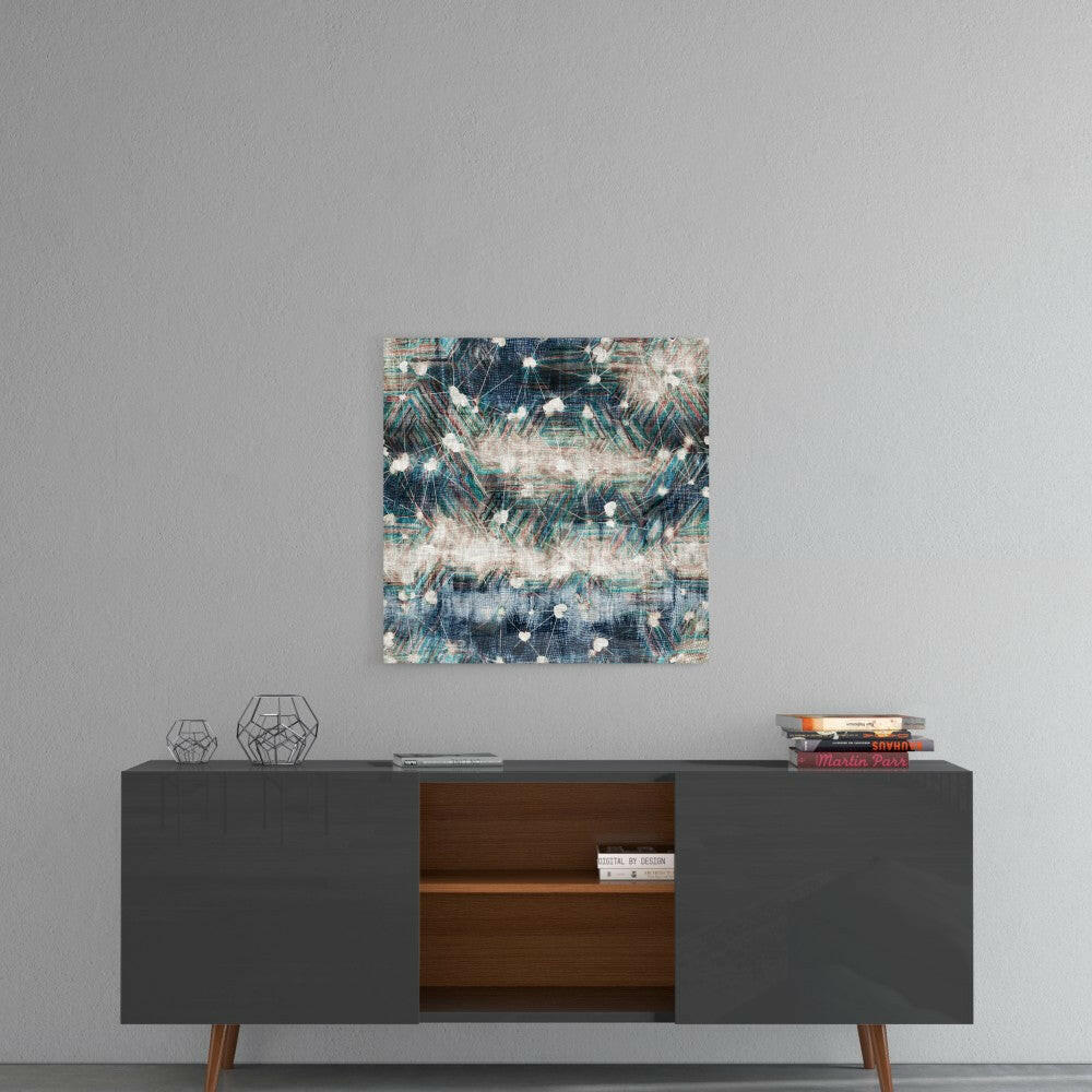 Abstract blue, teal, and cream glass wall art hung above a mid-century modern credenza with geometric decor and stacked books.