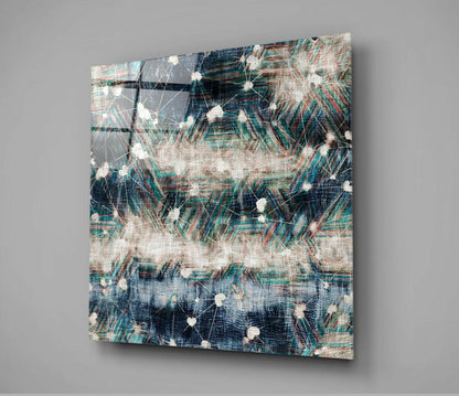 Angled view of glass wall art with layered navy, teal, and cream abstract pattern featuring white dot accents and textured grid overlay.