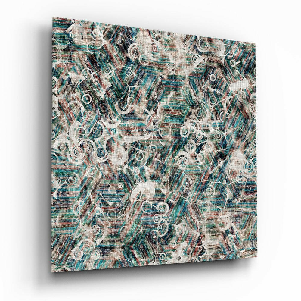 Angled perspective of glass wall art displaying layered teal, cream, and burgundy abstract circular patterns on textured linen background.