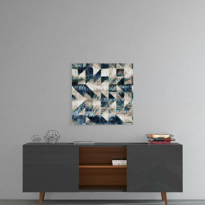 Abstract geometric glass wall art with navy, teal, and cream triangular pattern displayed above mid-century modern sideboard.