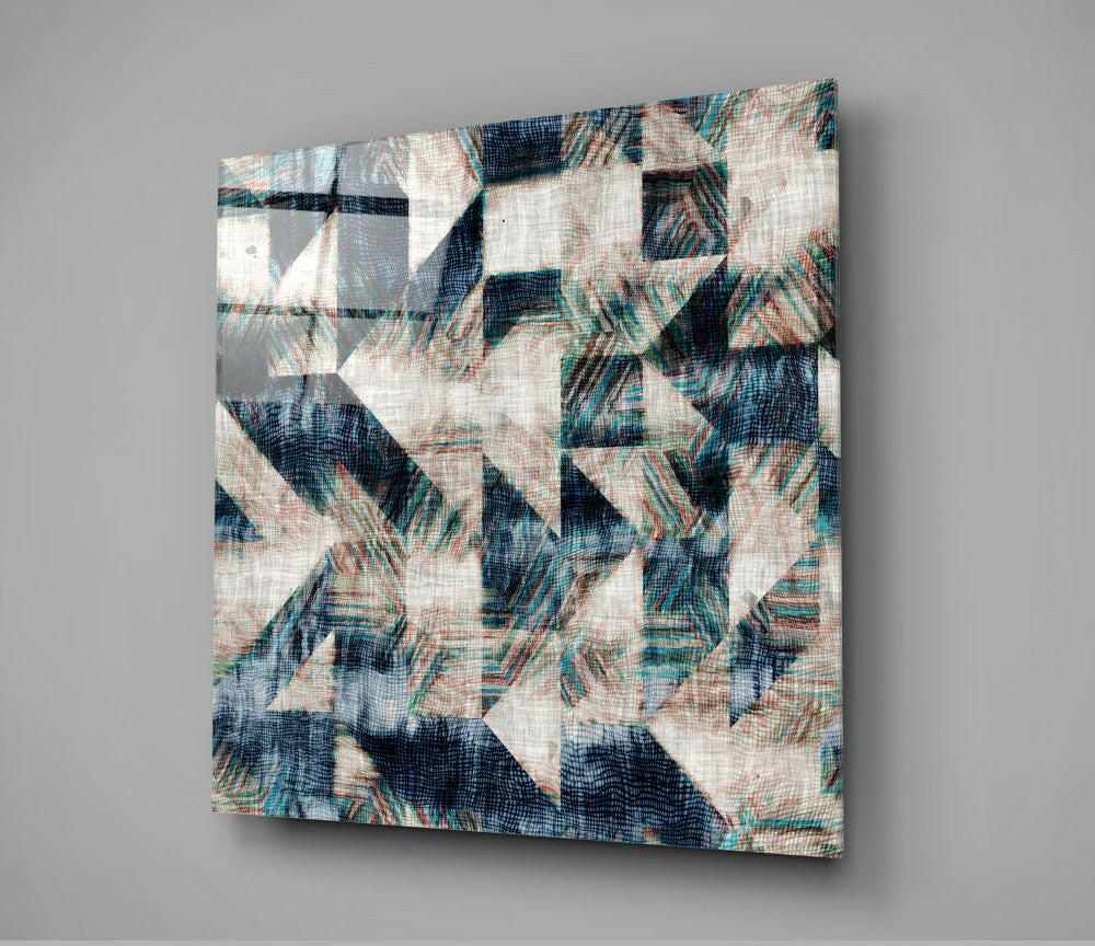 Angled view of glass wall art with abstract patchwork design in navy, teal, cream, and rust tones on textured surface.