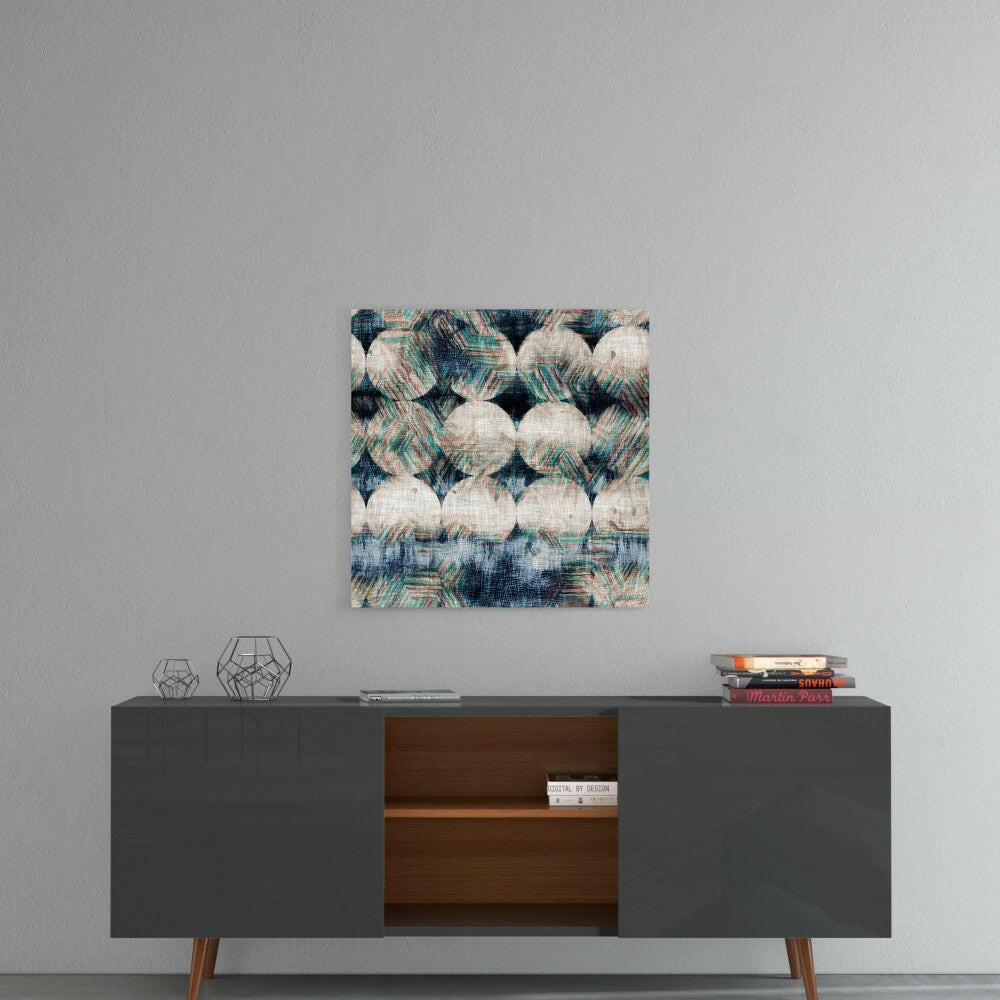 Square glass wall art with woven textile pattern in cream, navy, and teal displayed above mid-century modern credenza.