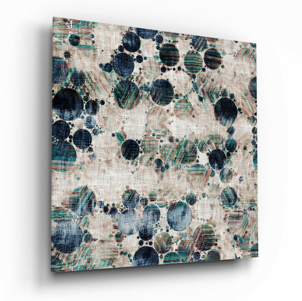 Angled view of textured glass wall art displaying dark navy and teal circular microscopic forms with linear patterns on cream linen background.