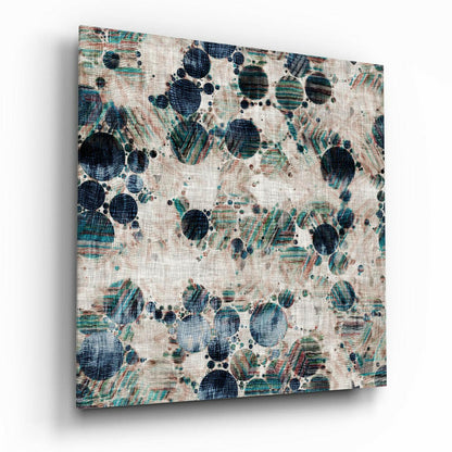 Angled view of textured glass wall art displaying dark navy and teal circular microscopic forms with linear patterns on cream linen background.