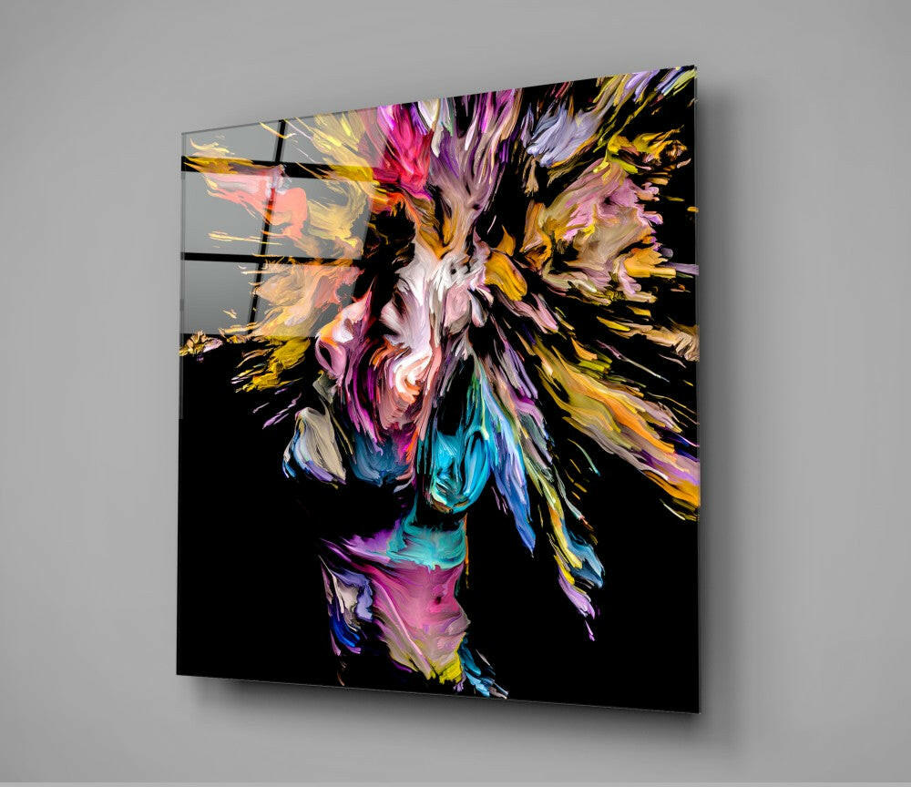 Colorful abstract paint explosion in magenta, gold, blue, and pink bursting from center on black glass panel mounted at angle.