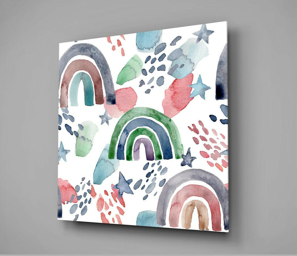 Watercolor glass wall art displayed at an angle showing multiple colorful rainbows, stars, and abstract shapes in blue, green, pink, and gray tones on white background.