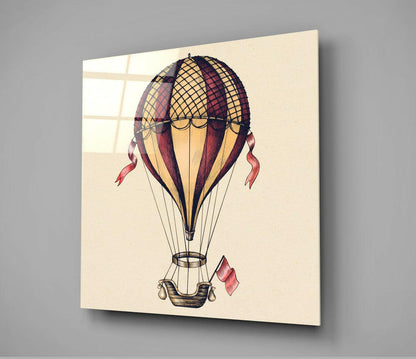 Vintage-style hot air balloon illustration on cream glass with red and gold coloring, displayed at an angle showing the three-dimensional mounted piece.
