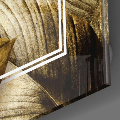 Close-up angled view of gold leaf glass wall art with white trim edge against gray background, showing textured gold and cream layered design.