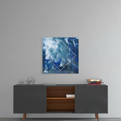 Blue and white abstract cloud glass art with white diamond outline displayed above modern credenza with geometric decor.