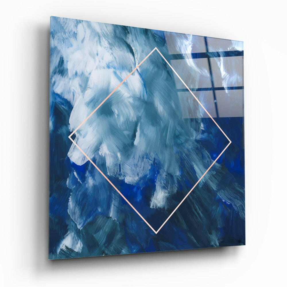 Square glass wall art featuring a rotated diamond shape with white outline against blue and white brushstroke background, displayed at an angle.