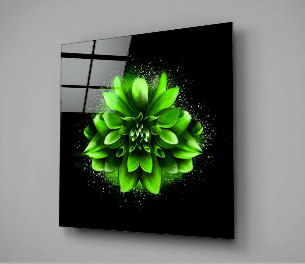 Angled view of black glass wall art displaying a vibrant neon green flower with particle effects against dark background.