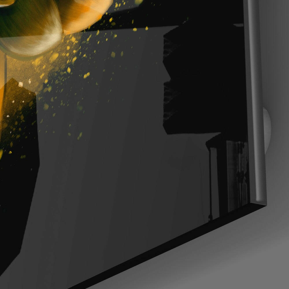 Yellow lotus petals cascade from tilted glass vessel onto dark surface, close-up overhead view.