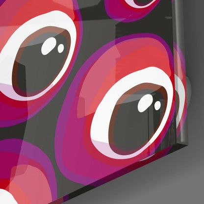 Close-up angled view of red and pink glass evil eye beads with white and brown details against gray background.