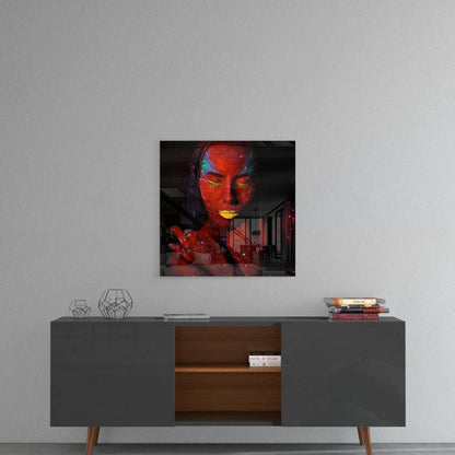 Ruby Woman Glass Wall Art displayed above a mid-century modern console table, showing vibrant red and gold painted face with architectural interior backdrop.