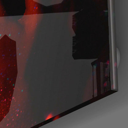 Red and blue illuminated glass wall art panel with silhouetted female profile, installed on gray wall at angle.