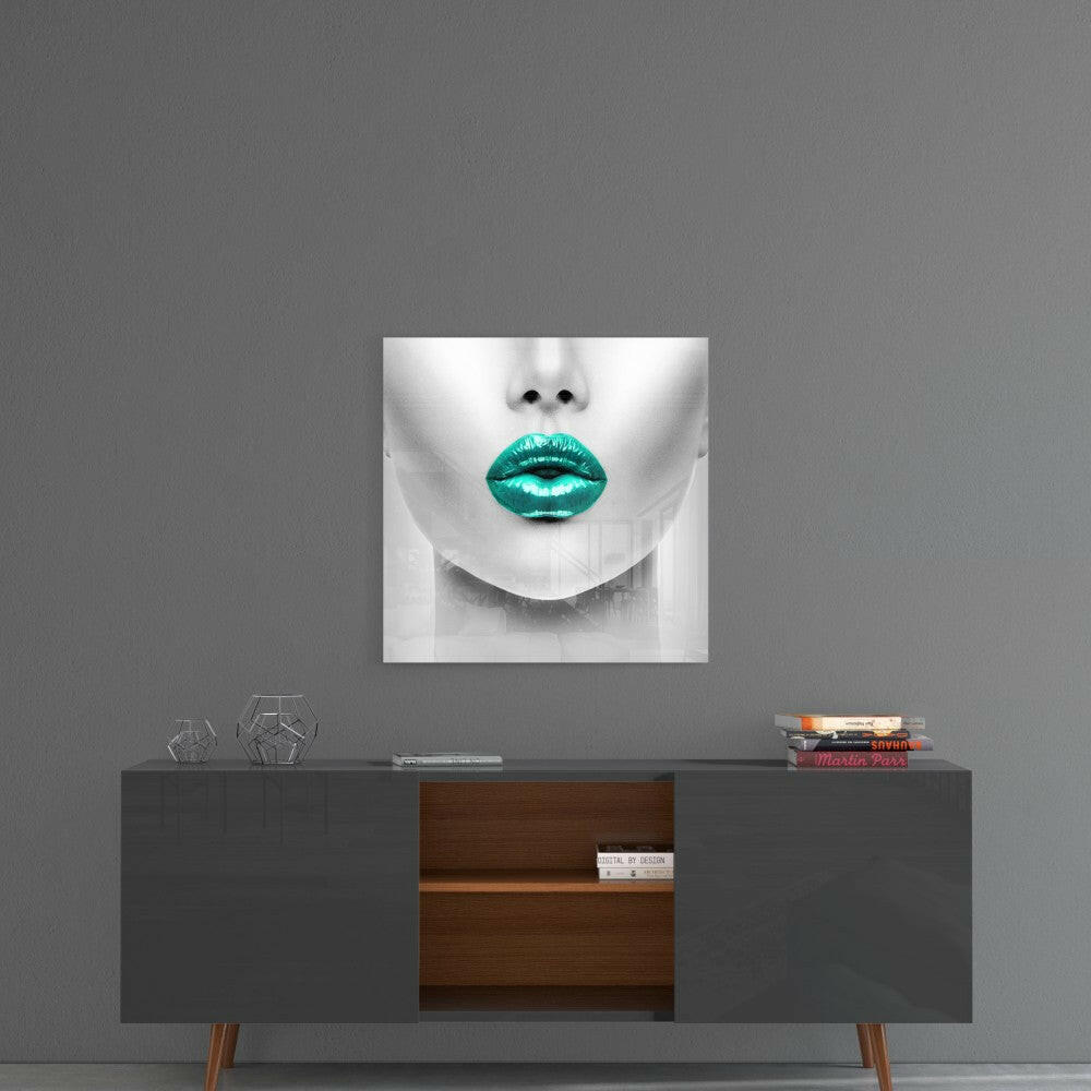 Square glass wall art featuring a monochrome face with turquoise lips displayed above a mid-century modern credenza.