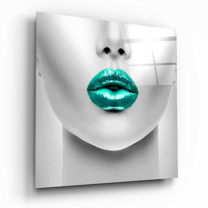 Close-up of monochrome face with vibrant turquoise glossy lips on frosted glass panel, angled three-quarter view.