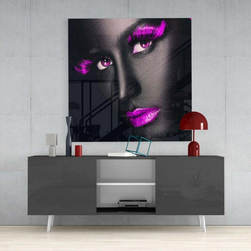 Modern living room display featuring Pink Lashes Glass Wall Art mounted above gray media console with red lamp and accessories.