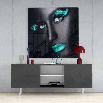Modern living room interior with gray media console displaying neon cyan-lashed face portrait above, styled with red lamp and accessories.