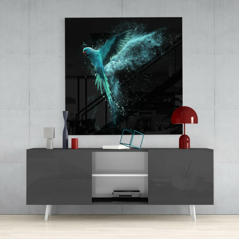 Turquoise glowing parrot with dispersing particles displayed as wall art above gray media console with red accents.