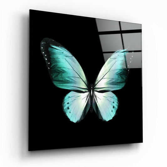 Angled perspective view of turquoise and white butterfly glass wall art with black grid pattern visible in upper right corner.
