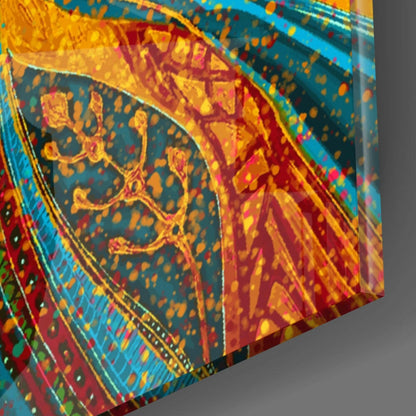 Angled close-up of multicolored glass wall art showing layered red, yellow, blue, and green decorative patterns with ornamental designs.