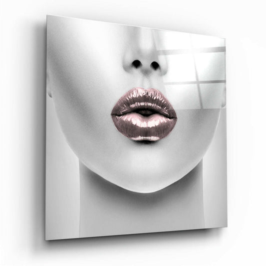 Close-up front view of a monochromatic face with rose gold metallic lips displayed on a glass panel with grid pattern.