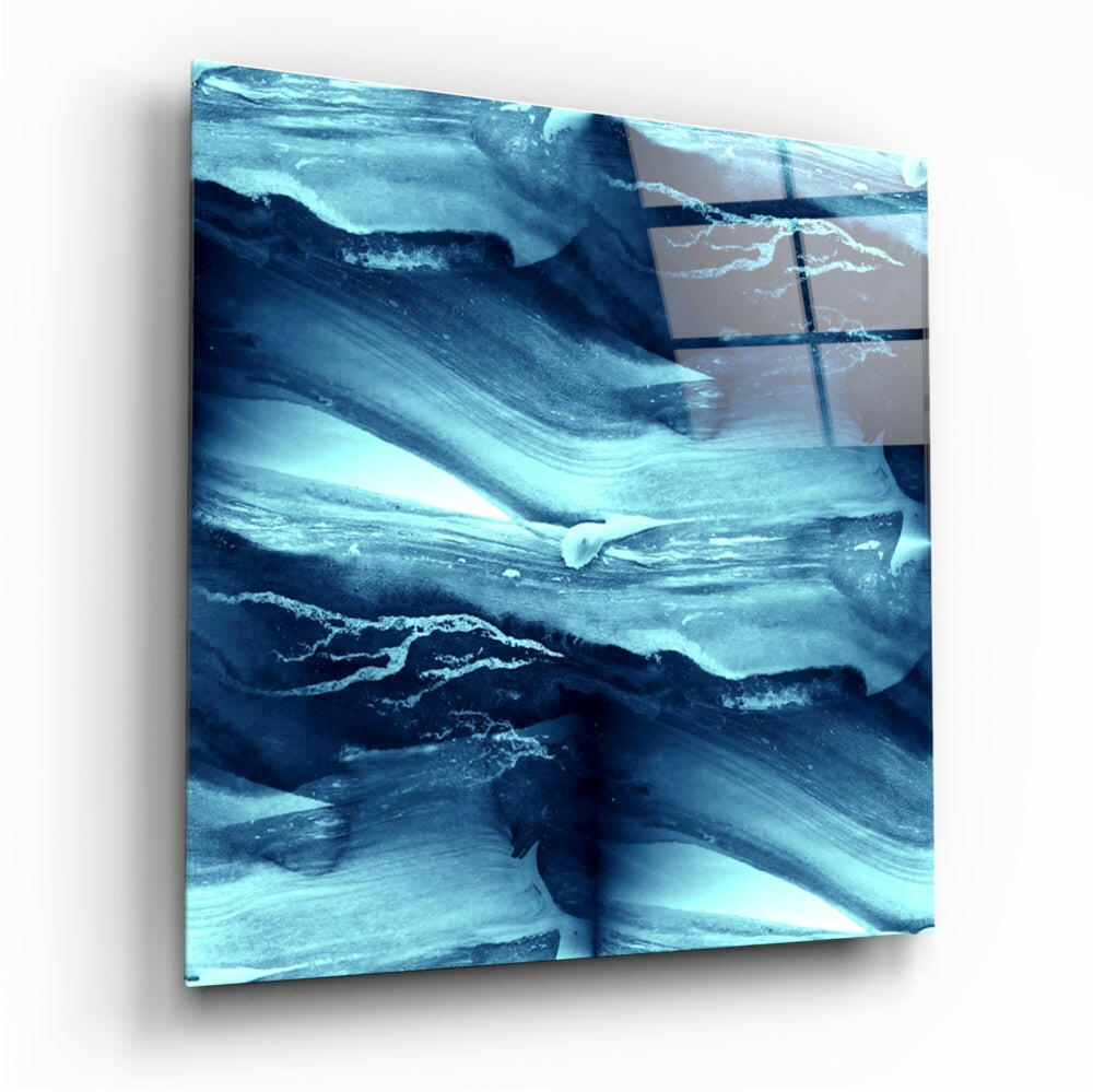 Modern glass wall art with layered blue and teal brushstroke patterns displayed at an angled perspective against white background.