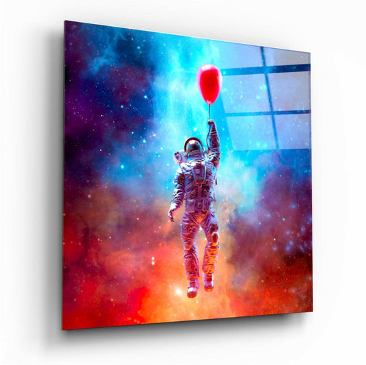 Angled view of glass wall art showing astronaut holding red balloon against vibrant blue and orange cosmic background.