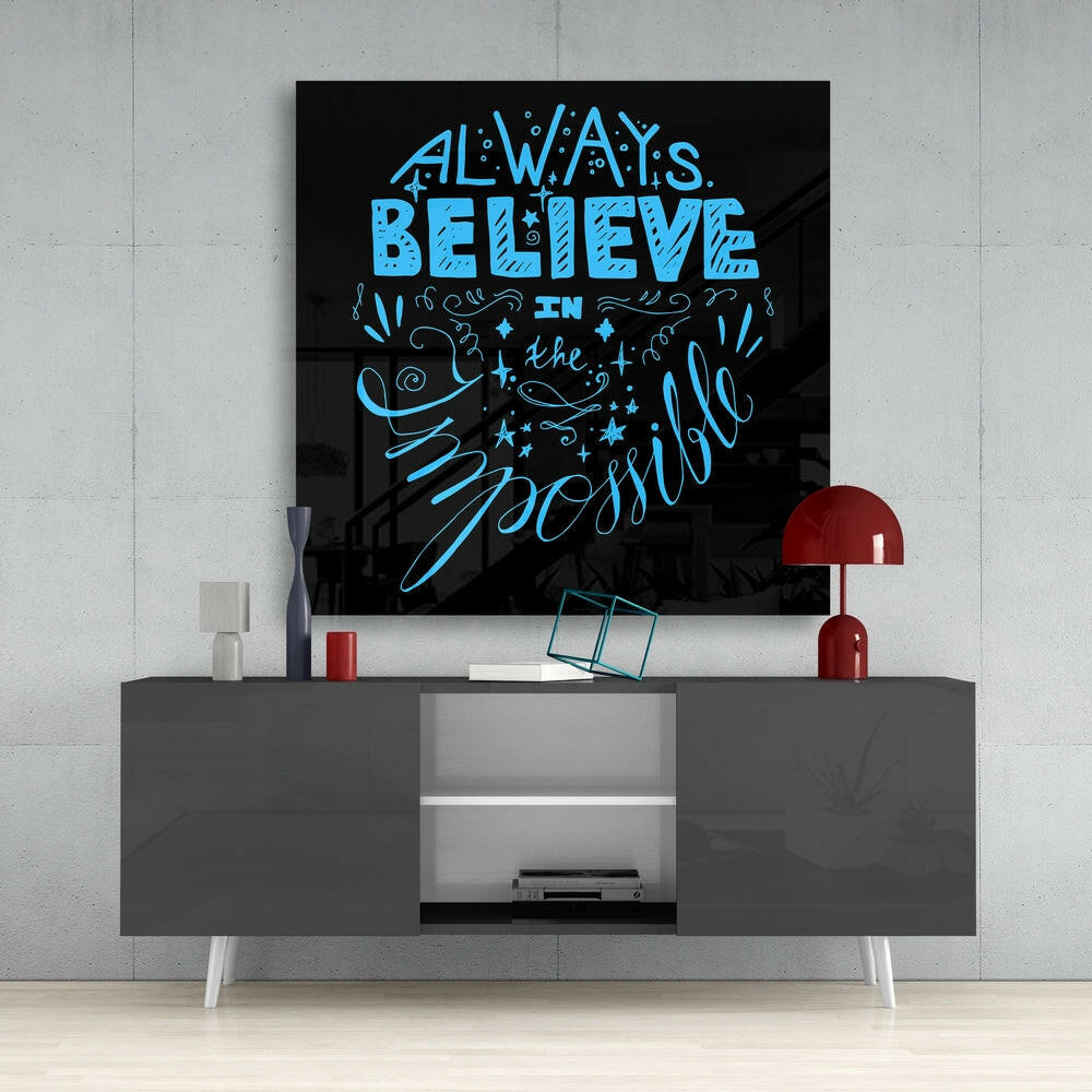 Blue neon-style text reading "Always Believe in the Impossible" on black glass mounted above gray media console with red lamp.