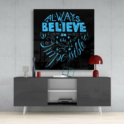Blue neon-style text reading "Always Believe in the Impossible" on black glass mounted above gray media console with red lamp.